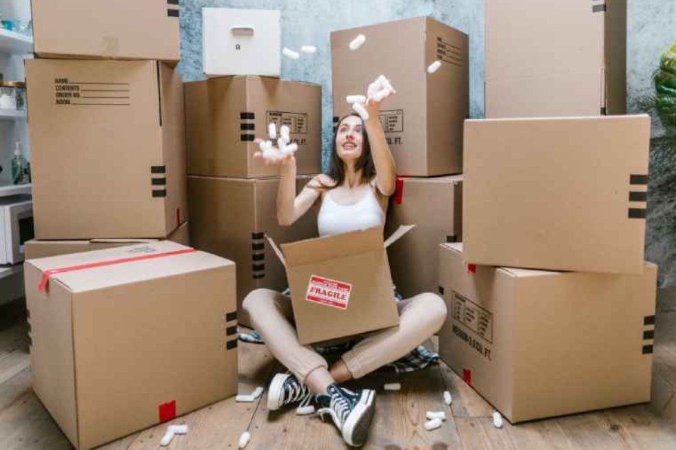 a girl sitting in a room with boxes