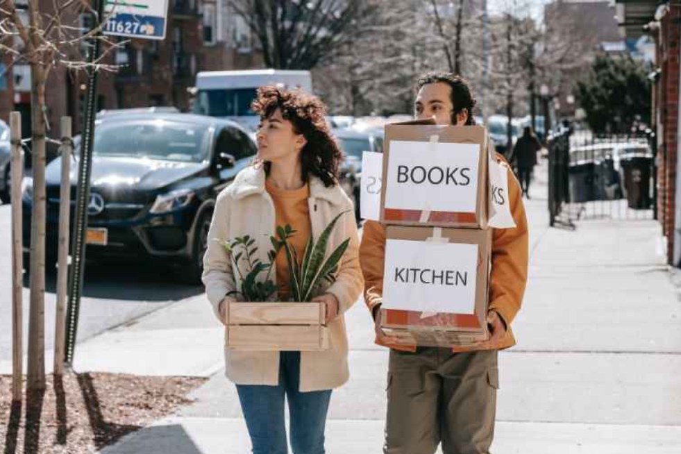 a girl and boy carrying boxes with signs