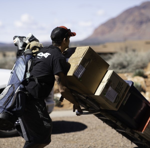 a man taking some boxes on a trolley