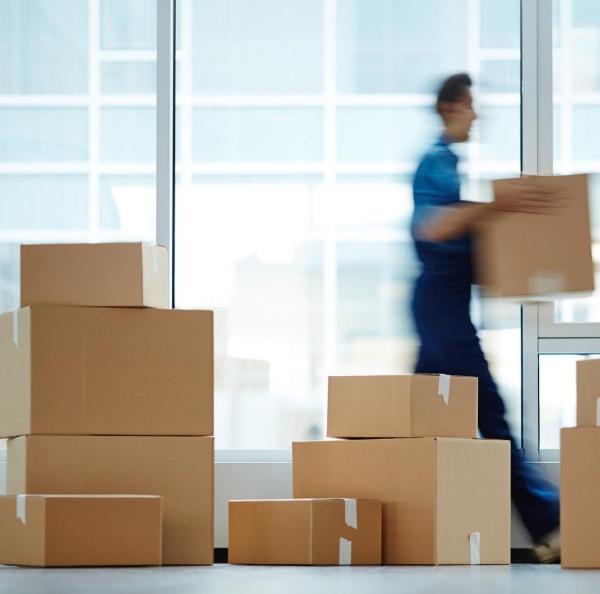 a man moving cardboard boxes