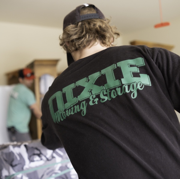 A man is wearing Dixie moving and storage black t-shirt