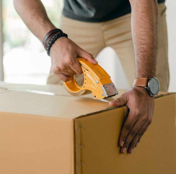 a man using a tape gun to seal a box