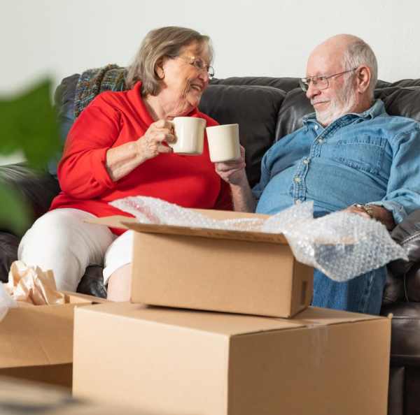 a man and woman sitting on a couch holding cups