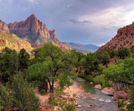 a river running through a canyon in the background